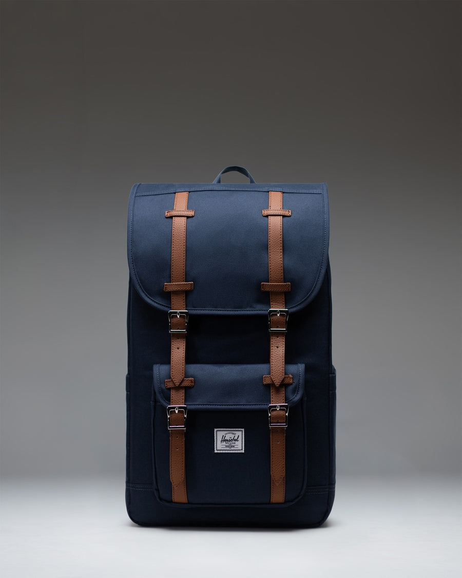 Navy blue Herschel Little America Backpack with classic front pocket and brown fastening straps.