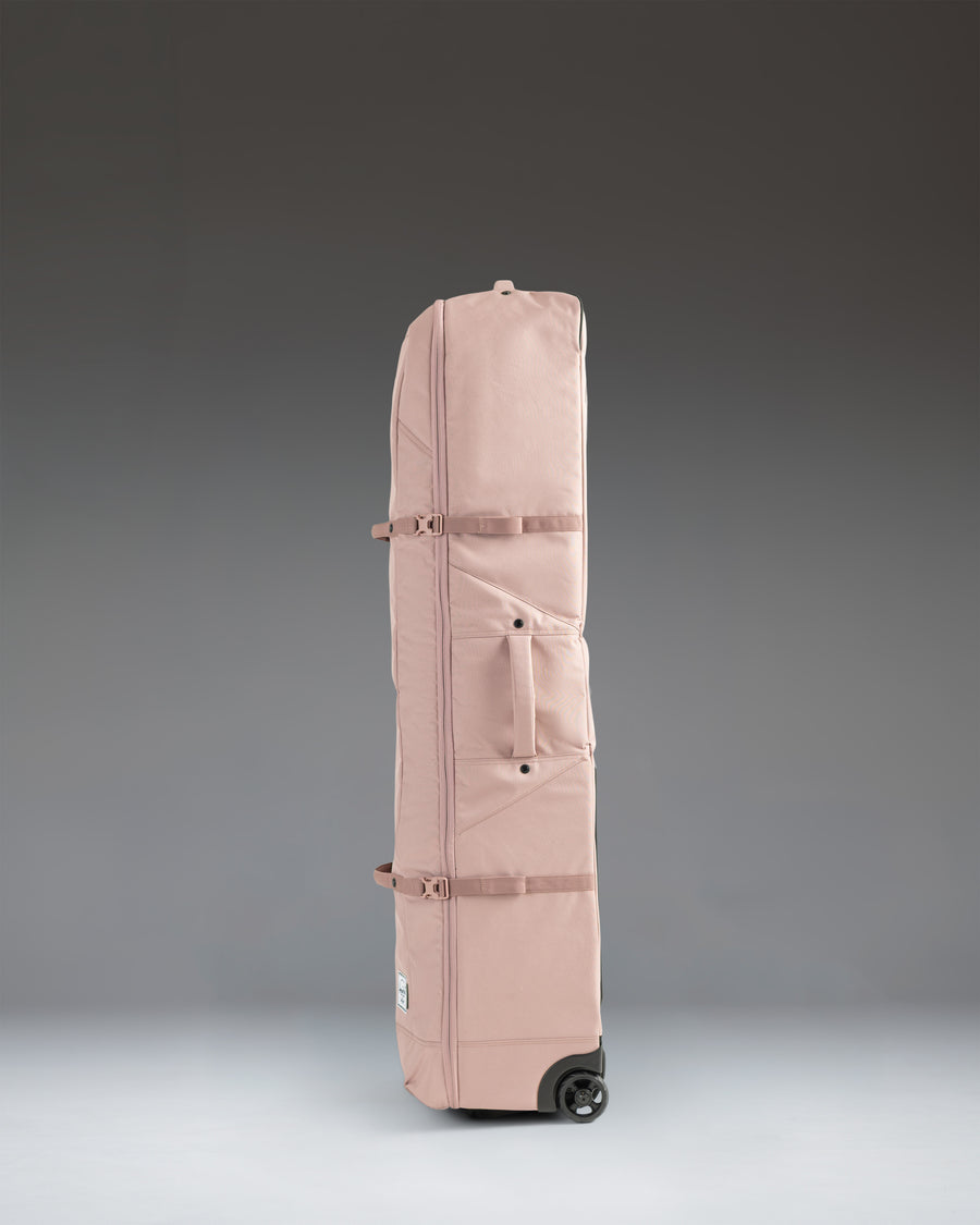 Herschel Heritage Golf Travel Wheelie Bag in Ash Rose, a durable rolling travel bag designed for protecting golf clubs and gear.