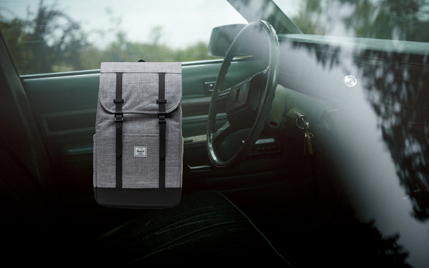 Herschel Retreat Backpack in Raven Crosshatch grey fabric, styled on a desktop background display.