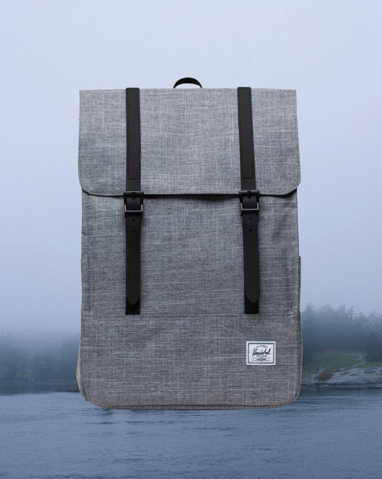 Herschel Survey Backpack in Raven Crosshatch heather grey with dual magnetic strap closures, shown from the front.
