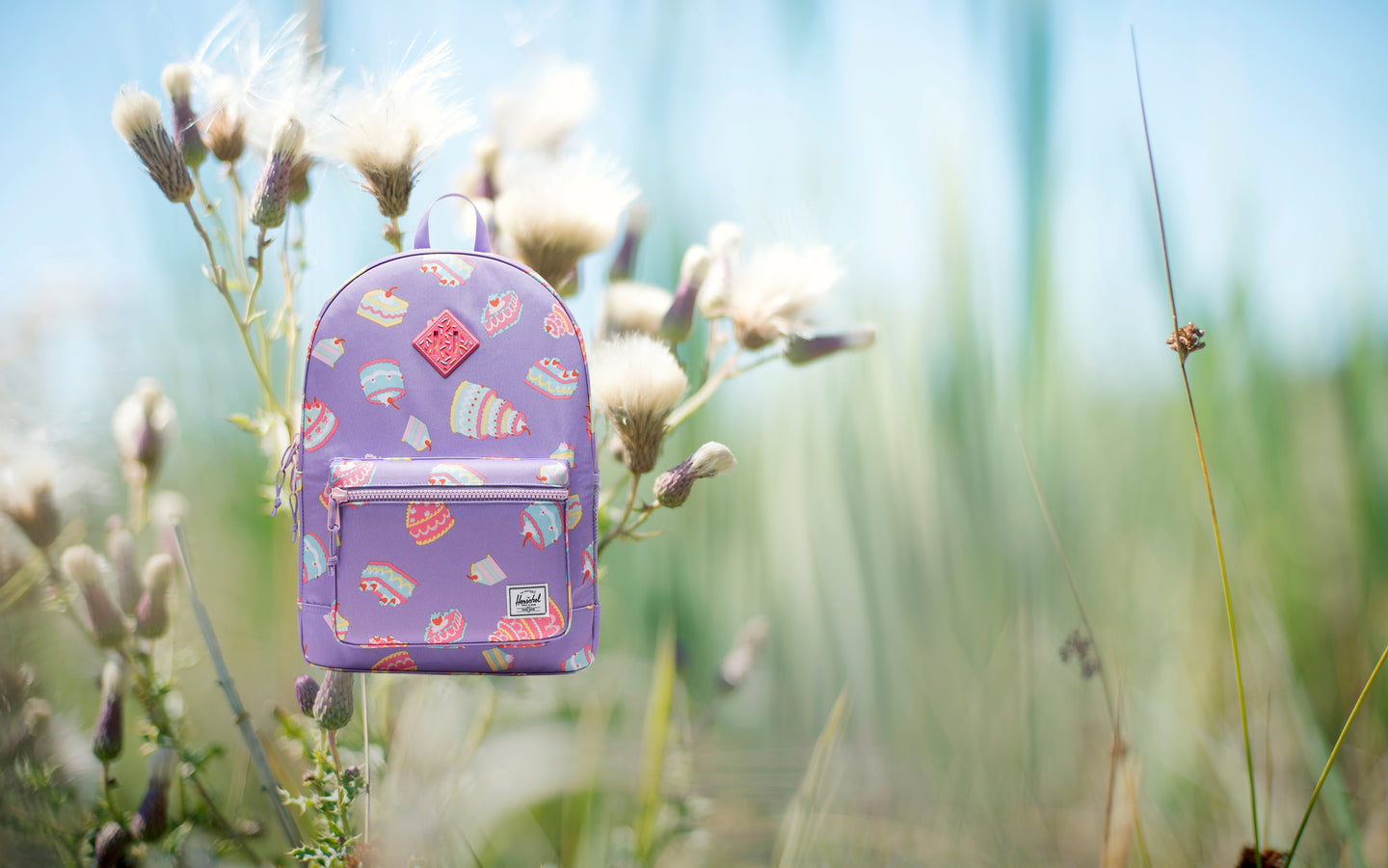Herschel Heritage Youth Backpack in Cakes featuring a playful cake-themed print with a spacious main compartment and a front pocket.