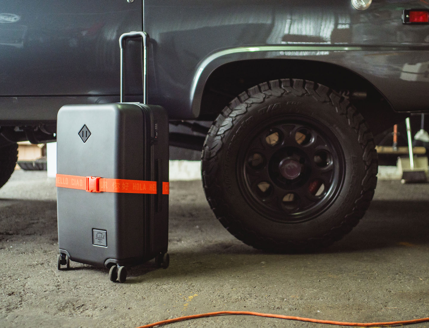 Herschel Supply Co. Tangerine Tango orange luggage belt displayed on a clean background.