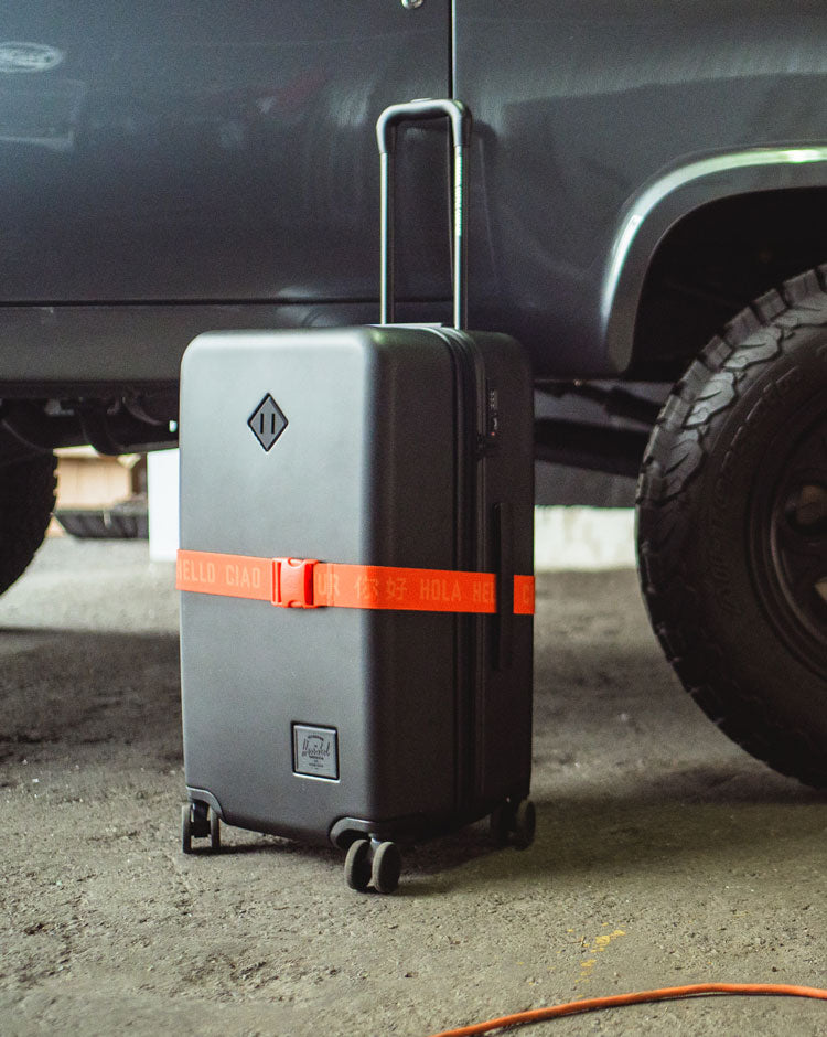 Herschel Supply Co. adjustable Luggage Belt in Tangerine Tango orange with a black clip closure, displayed against a clean background.